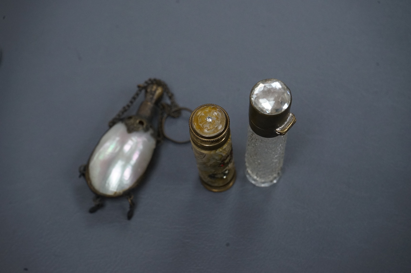 A pump-action scent flask or atomiser and two others, longest 8.5cm